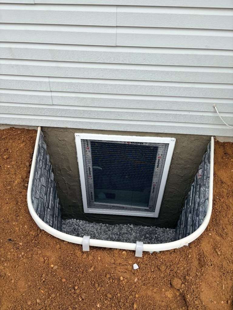 Newly installed Boman Kemp stacked stone egress window well with a European tilt-and-turn window on Long Island, NY